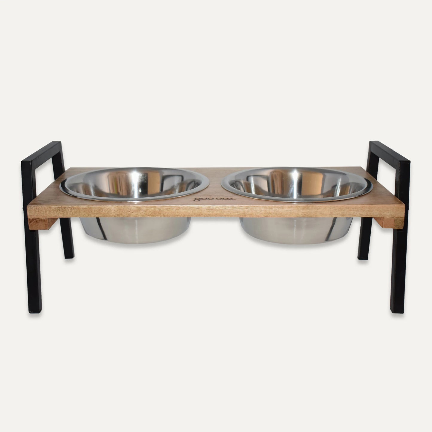 Pet feeding station with two stainless steel bowls on a wooden platform with black metal stands.