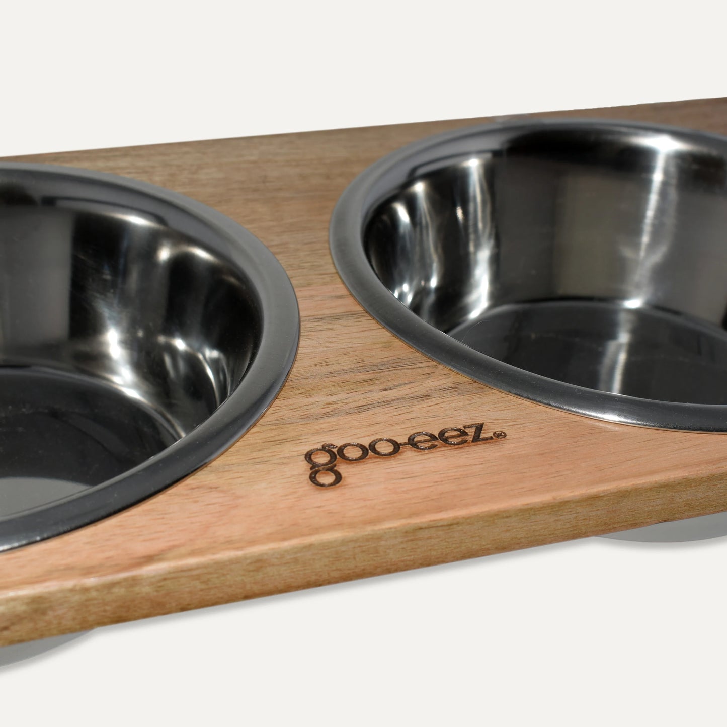 Two stainless steel bowls on a wooden tray with 'goo-eez' branding.
